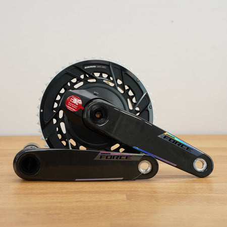 Bicycle crankset with chainring on a wooden surface