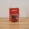 SRAM Accessories black and red component in clear plastic blister packaging, standing on a wooden surface against a light gray wall.