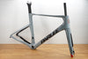 A light gray carbon fiber road bike frame with black and white 'PARLEE' branding, displayed on a wooden table against a white studio background.