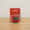 SRAM battery in a clear blister pack with a red backing card, placed on a light wooden surface against a plain light gray wall.