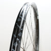 Close-up of a black DT Swiss bicycle wheel rim with white printed branding and thin silver spokes against a plain white background.