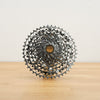 A silver SRAM Rival cassette photographed on a light wooden surface against a plain white backdrop.