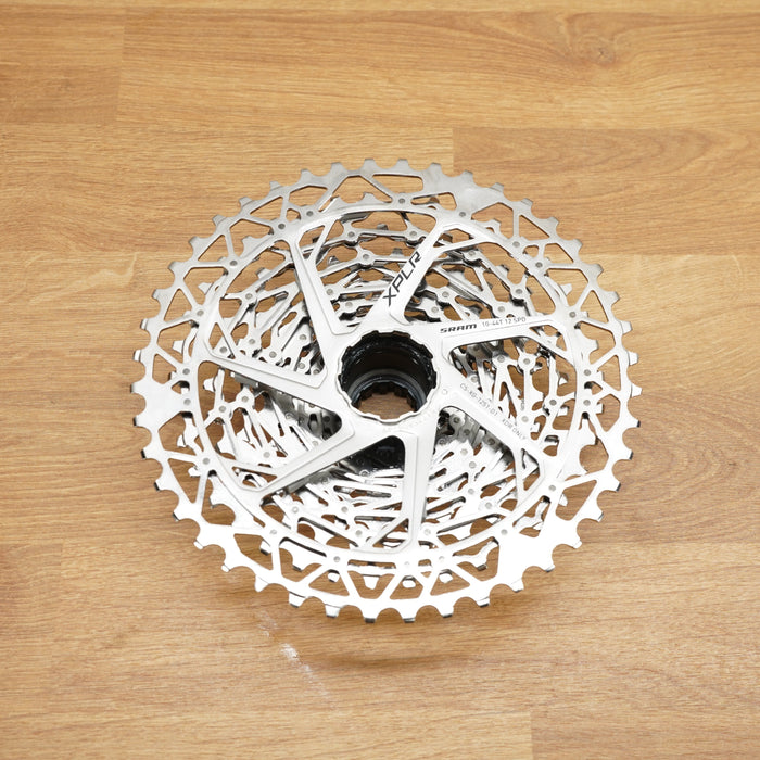 A silver SRAM Rival cassette photographed on a light wooden surface.
